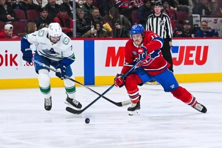 Jan 12, 2026; Montreal, Quebec, CAN; Montreal Canadiens right wing Brendan Gallagher (11) plays the puck against Vancouver Canucks defenseman Pierre-Olivier Joseph (7) during the second period at Bell Centre. Mandatory Credit: David Kirouac-Imagn Images