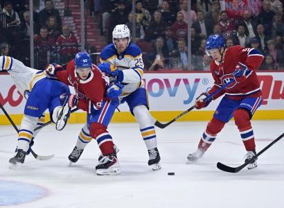 Oct 20, 2025; Montreal, Quebec, CAN; Montreal Canadiens forward Oliver Kapanen (91) and teammate forward Ivan Demidov (93) battle for the puck against Buffalo Sabres defenseman Owen Power (25) during the first period at the Bell Centre. Mandatory Credit: Eric Bolte-Imagn Images