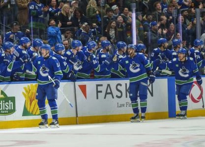 Dec 6, 2025; Vancouver, British Columbia, CAN; Vancouver Canucks center Aatu Raty (54) celebrates the Canucks third goal in the second period with teammates on the bench at Rogers Arena.
