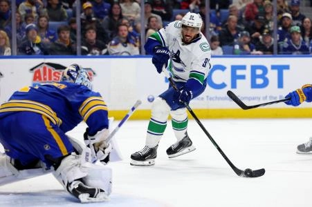 Jan 6, 2026; Buffalo, New York, USA; Vancouver Canucks left wing Evander Kane (91) takes a shot on Buffalo Sabres goaltender Ukko-Pekka Luukkonen (1) during the first period at KeyBank Center.