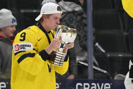 Jan 5, 2026; St. Paul, Minnesota, USA; Sweden defensemen Victor Johansson (9) kisses the first place trophy after defeating Czechia in the final of the 2026 IIHF World Junior Championship ice hockey tournament at Grand Casino Arena