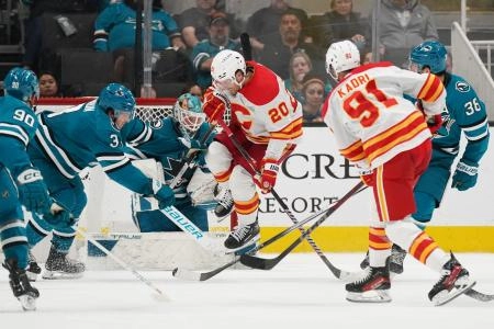 Apr 9, 2024; San Jose, California, USA; Calgary Flames center Blake Coleman (20) jumps over a shot by Calgary Flames center Nazem Kadri (91) against the San Jose Sharks during overtime at SAP Center at San Jose. Mandatory Credit: David Gonzales-Imagn Images