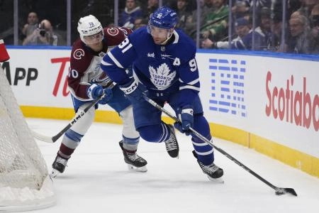 Mar 19, 2025; Toronto, Ontario, CAN; Toronto Maple Leafs forward John Tavares (91) controls the puck against Colorado Avalanche defenseman Sam Malinski (70) during the third period at Scotiabank Arena. Mandatory Credit: John E. Sokolowski-Imagn Images