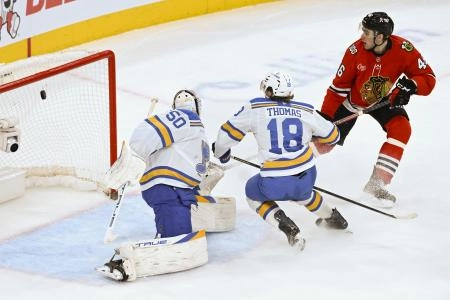 Jan 7, 2026; Chicago, Illinois, USA; Chicago Blackhawks defenseman Louis Crevier (46) scores a goal past St. Louis Blues goaltender Jordan Binnington (50) and center Robert Thomas (18) during the third period at the United Center. Mandatory Credit: Matt Marton-Imagn Images
