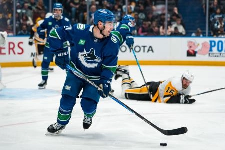 Jan 25, 2026; Vancouver, British Columbia, CAN; Vancouver Canucks forward Nils Hoglander (21) handles the puck against the Pittsburgh Penguins in the third period at Rogers Arena.