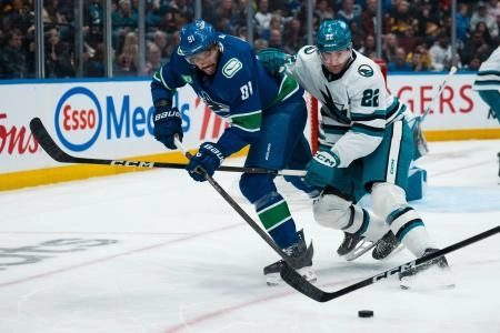 Dec 27, 2025; Vancouver, British Columbia, CAN; San Jose Sharks defenseman Vincent Iorio (22) checks Vancouver Canucks forward Evander Kane (91) in the second period at Rogers Arena. Mandatory Credit: Bob Frid-Imagn Images