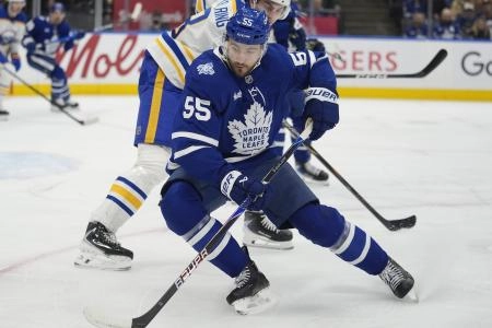 Jan 27, 2026; Toronto, Ontario, CAN; Toronto Maple Leafs forward Nick Roy (55) tries to control the puck against Buffalo Sabres defenseman Michael Kesselring (8) during the first period at Scotiabank Arena. Mandatory Credit: John E. Sokolowski-Imagn Images