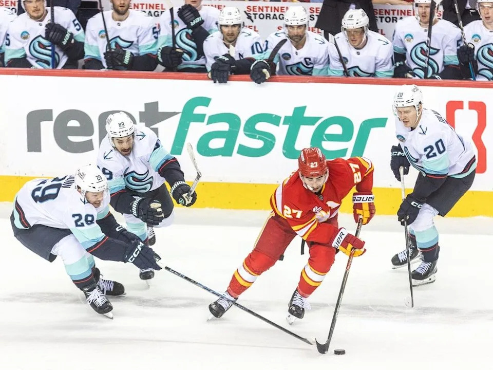  Calgary Flames right winger Matt Coronato is dogged by the Seattle Kraken in the third period at the Scotiabank Saddledome on Monday, January 5, 2026. Brent Calver/Postmedia