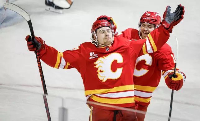 Calgary Flames' Connor Zary, left, celebrates his goal with teammate John Beecher during third period NHL hockey action in Calgary on Wednesday, Dec. 31, 2025. (Jeff McIntosh/The Canadian Press via AP)
