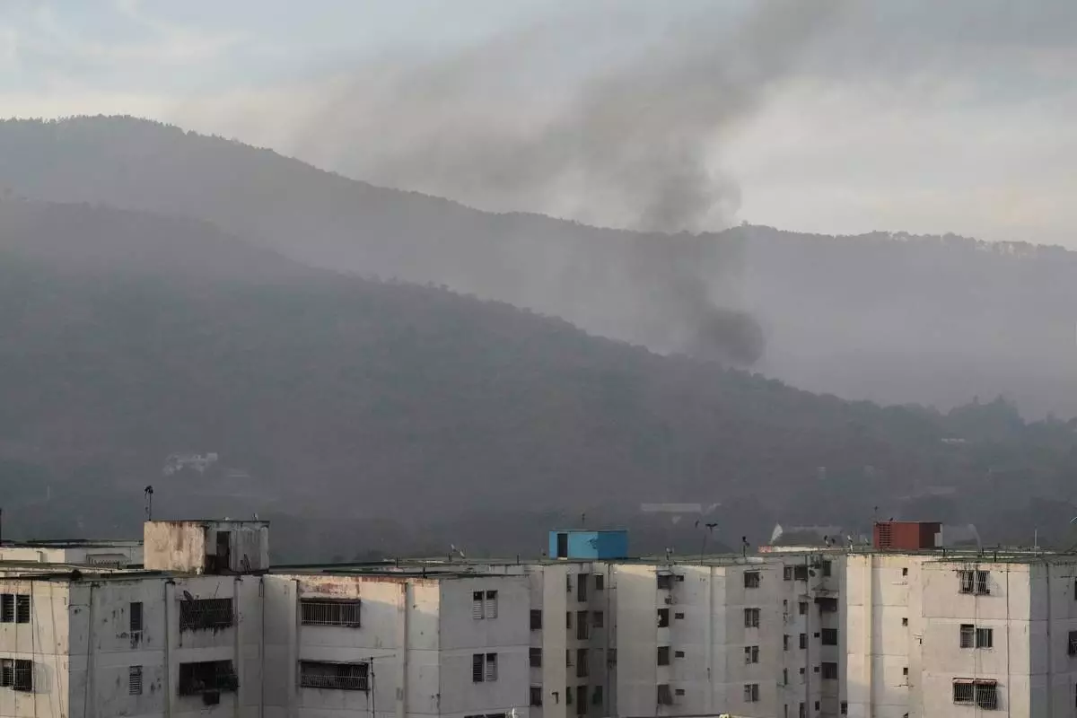 Smoke rises from Fort Tiuna, the main military garrison in Caracas, Venezuela, after multiple explosions were heard and aircraft swept through the area, Saturday, Jan. 3, 2026. (AP Photo/Matias Delacroix)