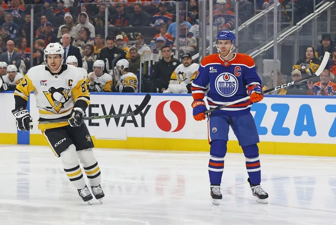 Jan 22, 2026; Edmonton, Alberta, CAN; Edmonton Oilers forward Connor McDavid (97) and Pittsburgh Penguins forward Sidney Crosby (87) look for a loose puck during the first period at Rogers Place.