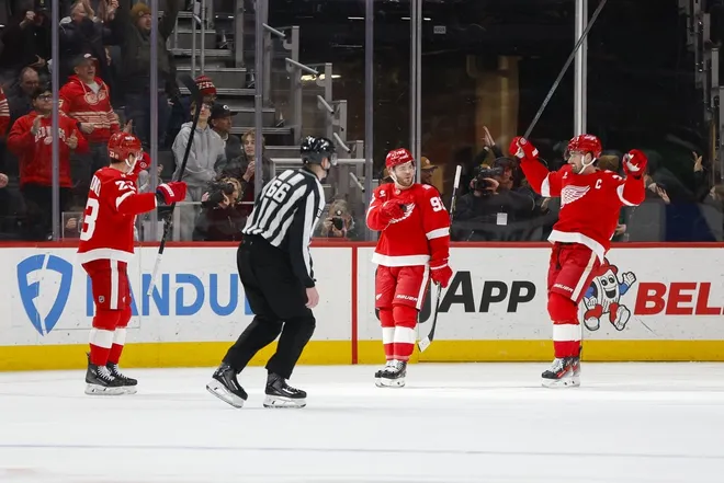 Jan 27, 2026; Detroit, Michigan, USA; Detroit Red Wings right wing Alex DeBrincat (93) celebrates a goal with teammates center Dylan Larkin (71) and left wing Lucas Raymond (23) during the third period against the Los Angeles Kingsat Little Caesars Arena.