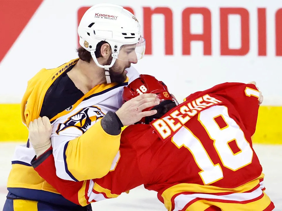  The Nashville Predators’ Nicolas Hague, left, fights with the Calgary Flames’ John Beecher during second-period NHL action in Calgary on Saturday, Jan. 3, 2026.