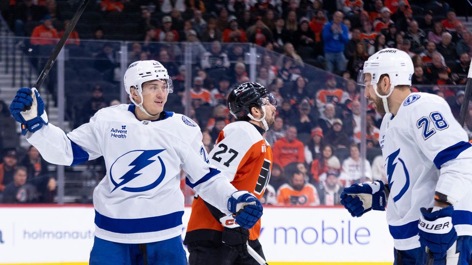 Tampa Bay Lightning's Pontus Holmberg, left, reacts to his goal with Zemgus Girgensons, right, as Philadelphia Flyers' Noah Cates, center, skates by during the first period of an NHL hockey game, Monday, Jan. 12, 2026, in Philadelphia. (AP Photo/Chris Szagola)