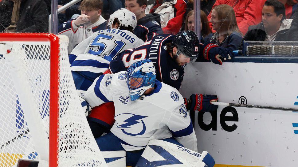 Tampa Bay Lightning's Jonas Johansson, front, gets caught up behind the net as teammate Charle-Edouard D'Astous, left, and Columbus Blue Jackets' Adam Fantilli fight for the puck during the first period of an NHL hockey game, Saturday, Jan. 24, 2026, in Columbus, Ohio. (AP Photo/Jay LaPrete)