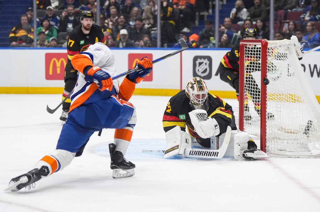 Vancouver Canucks goalie Kevin Lankinen, front right, watches the puck as New York Islanders' Maxim Tsyplakov, left, puts a shot off the side of the net during the first period of an NHL hockey game in Vancouver, British Columbia, Monday, Jan. 19, 2026.