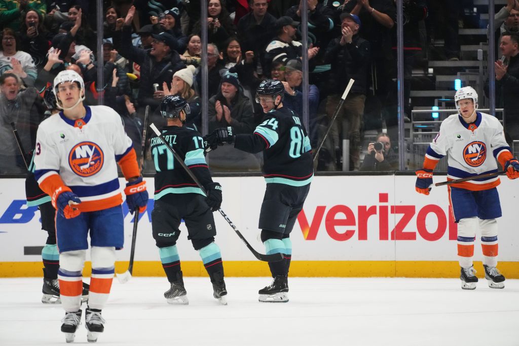 Seattle Kraken right wing Kaapo Kakko (84) celebrates his goal with left wing Jaden Schwartz (17) as New York Islanders left wing Emil Heineman, right, looks on during the second period of an NHL hockey game Wednesday, Jan. 21, 2026, in Seattle.