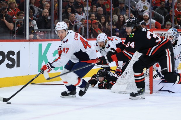 Blackhawks center Ryan Donato (8) falls to the ice as Capitals defenseman Declan Chisholm (47) moves the puck in the first period at the United Center on Jan. 9, 2026, in Chicago. (John J. Kim/Chicago Tribune)