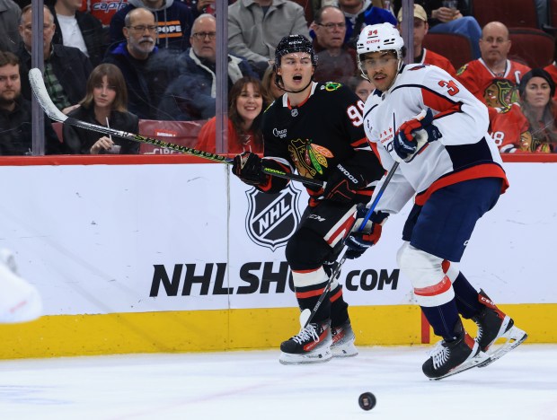 Blackhawks center Connor Bedard (98) and Capitals right wing Justin Sourdif (34) watch the puck in the third period at the United Center on Jan. 9, 2026, in Chicago. (John J. Kim/Chicago Tribune)