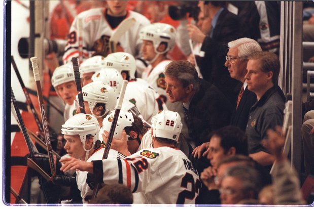 New coach Bob Pulford watches a Blackhawks-Red Wings game with associate head coach Lorne Molleken on Dec. 3, 1999. (Charles Cherney/Chicago Tribune)