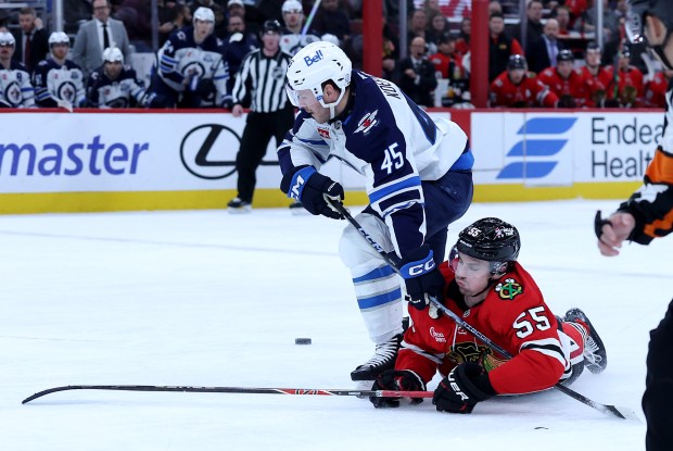 Winnipeg Jets left wing Cole Koepke (45) and Chicago Blackhawks defenseman Artyom Levshunov (55) battle in the second period of a game at the United Center in Chicago on Jan. 19, 2026. (Chris Sweda/Chicago Tribune)