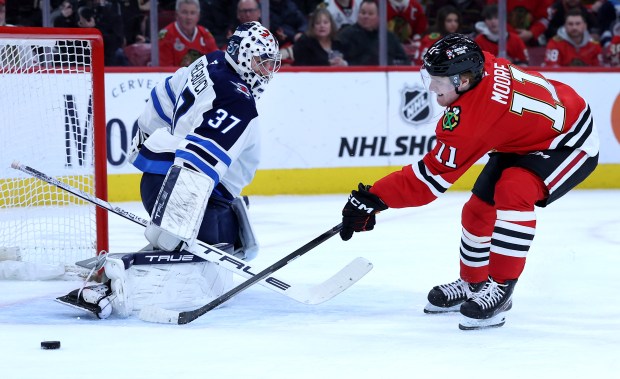 Chicago Blackhawks center Oliver Moore (11) is unable to score on Winnipeg Jets goaltender Connor Hellebuyck (37) in the first period of a game at the United Center in Chicago on Jan. 19, 2026. (Chris Sweda/Chicago Tribune)