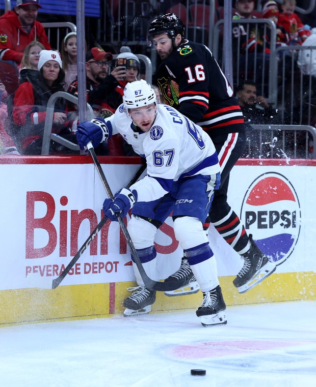 Tampa Bay Lightning defenseman Declan Carlile (67) and Chicago Blackhawks center Jason Dickinson (16) battle in the first period of a game at the United Center in Chicago on Jan. 23, 2026. (Chris Sweda/Chicago Tribune)