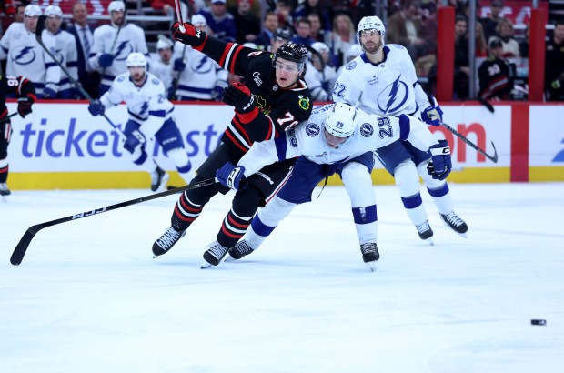 Chicago Blackhawks left wing Nick Lardis (76) and Tampa Bay Lightning right wing Pontus Holmberg (29) battle in the third period of a game at the United Center in Chicago on Jan. 23, 2026. (Chris Sweda/Chicago Tribune)