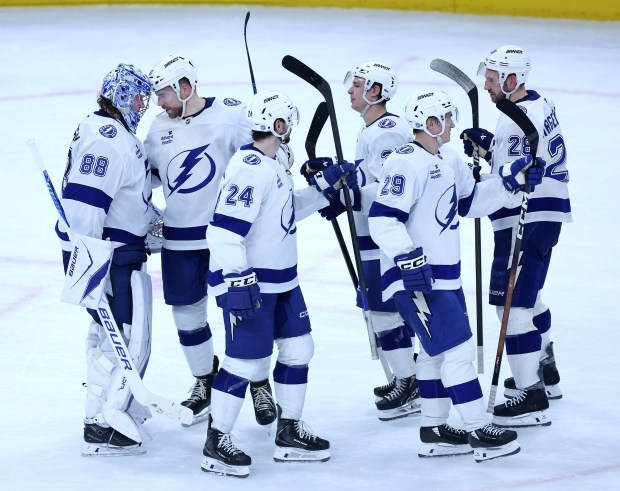 Tampa Bay Lightning goaltender Andrei Vasilevskiy (left) is congratulated by teammate Erik Cernak as the Lightning celebrate their shootout victory over the Chicago Blackhawks at the United Center in Chicago on Jan. 23, 2026. (Chris Sweda/Chicago Tribune)