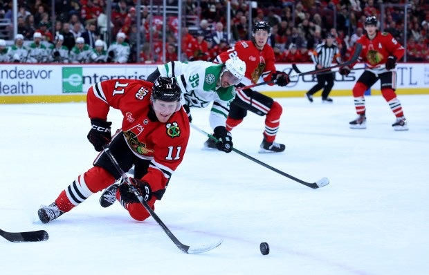 Chicago Blackhawks center Oliver Moore (11) tries to gain control of the puck in the first period of a game against the Dallas Stars at the United Center in Chicago on Jan. 1, 2026. (Chris Sweda/Chicago Tribune)