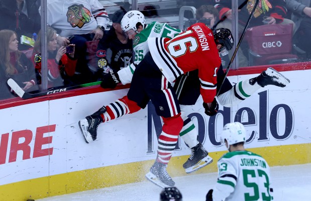 Chicago Blackhawks center Jason Dickinson (16) checks Dallas Stars defenseman Thomas Harley (55) into the boards in the third period of a game at the United Center in Chicago on Jan. 1, 2026. (Chris Sweda/Chicago Tribune)