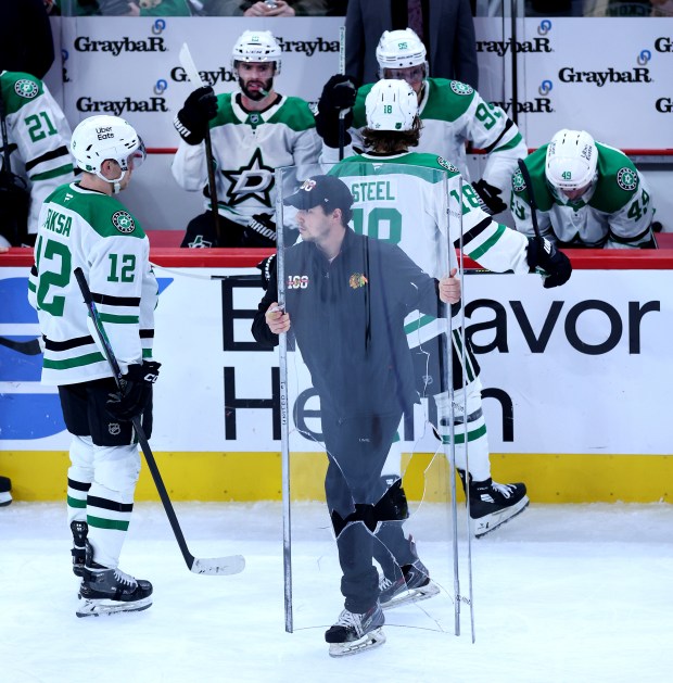 Broken glass is carried away from in front of the Dallas Stars bench in the second period of a game between the Stars and the Chicago Blackhawks at the United Center in Chicago on Jan. 1, 2026. (Chris Sweda/Chicago Tribune)