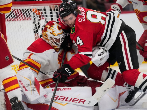 Blackhawks left wing Landon Slaggert, right, collides with Flames goaltender Devin Cooley during the third period Thursday, Jan. 15, 2026, at the United Center. (Erin Hooley/AP)