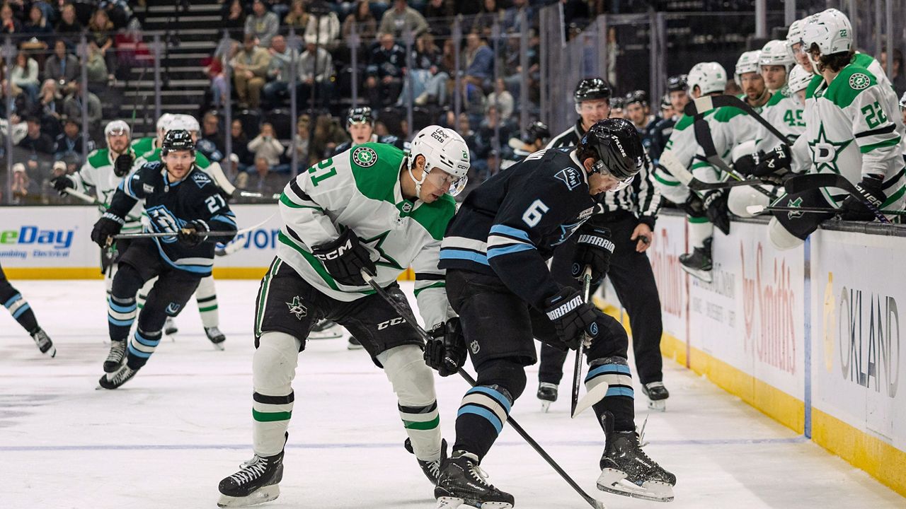 Dallas Stars left wing Jason Robertson, center left, fights for the puck against Utah Mammoth defenseman John Marino (6) during the second period of an NHL hockey game, Thursday, Jan. 15, 2026, in Salt Lake City. (AP Photo/Melissa Majchrzak)