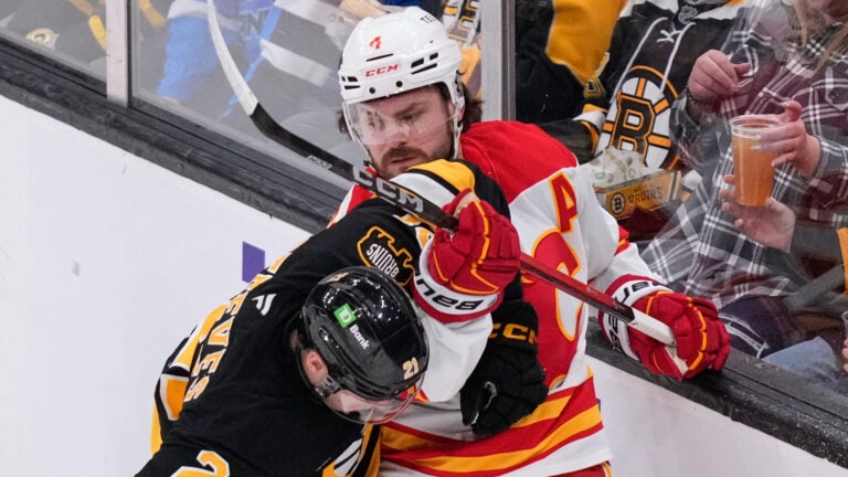 Calgary Flames defenseman Rasmus Andersson (4) tangles with Boston Bruins center Alex Steeves (21) during the first period of an NHL hockey game, Thursday, Jan. 8, 2026, in Boston.