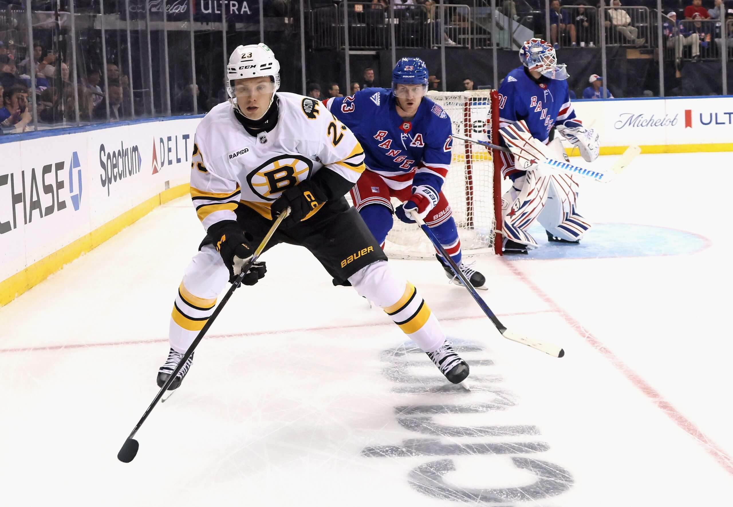 Fabian Lysell skates into a corner pursued by a Rangers player.