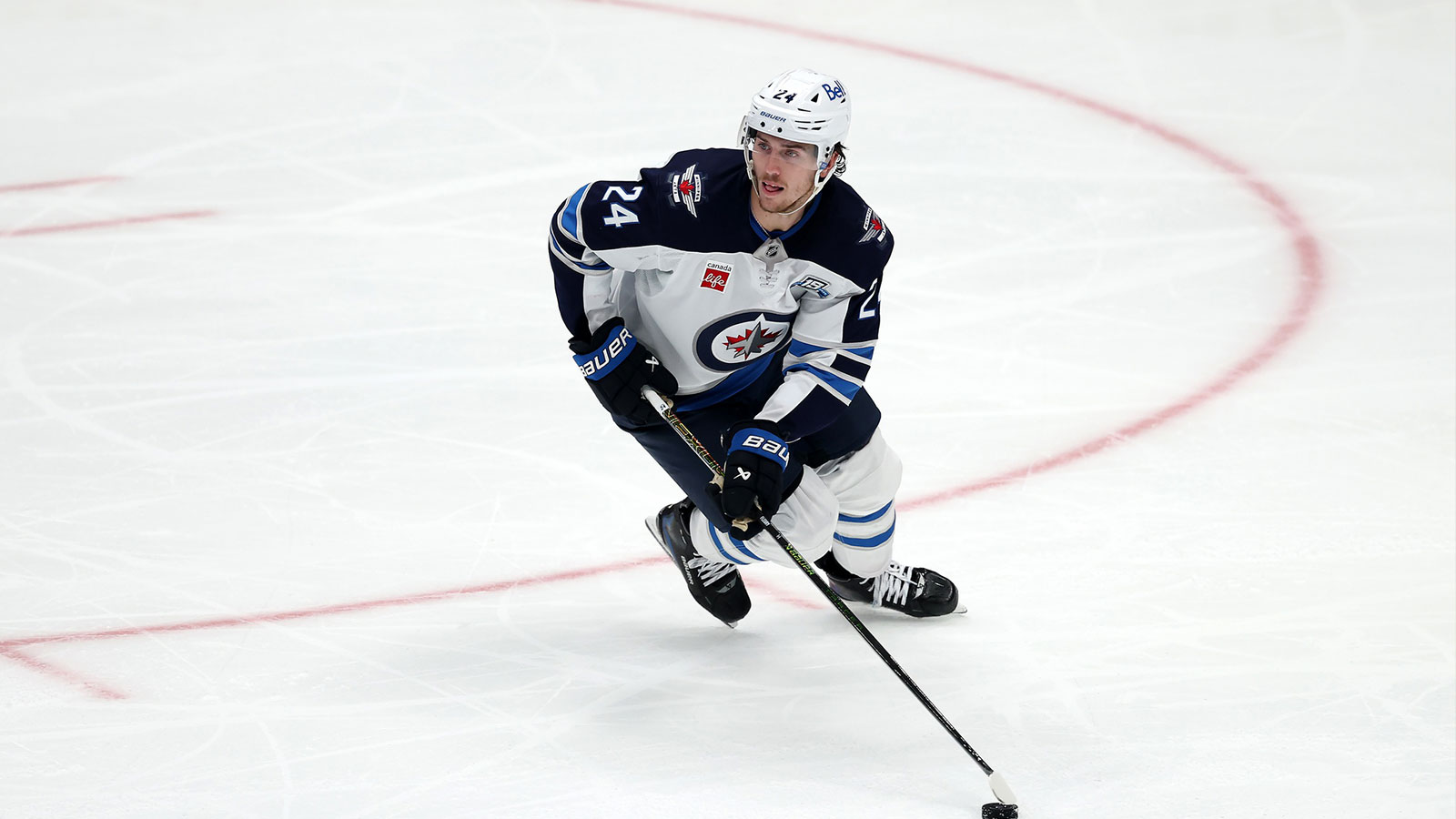 Winnipeg Jets defenseman Haydn Fleury (24) gets set to shoot the puck up the ice in a game against the Edmonton Oilers in the first period at Canada Life Centre.