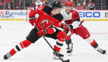 Luke Hughes plays the puck in front of Eric Robertson during the New Jersey Devils and Carolina Hurricanes game on Sunday night at the Prudential Center.