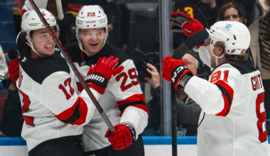 Cody Glass(12), Lenni Hameenaho(29) and Arseni Gritsyuk(81) celebrate Hameenaho's first career NHL goal in the first period of the New Jersey Devils' game against the Vancouver Canucks.