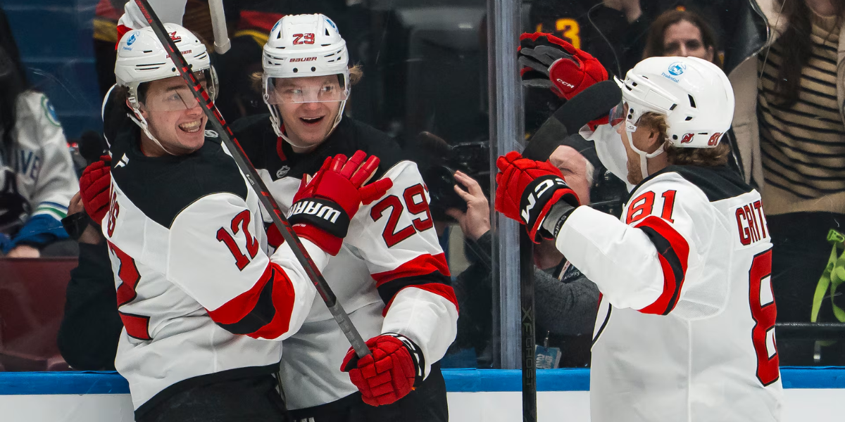 Cody Glass(12), Lenni Hameenaho(29) and Arseni Gritsyuk(81) celebrate Hameenaho's first career NHL goal in the first period of the New Jersey Devils' game against the Vancouver Canucks.