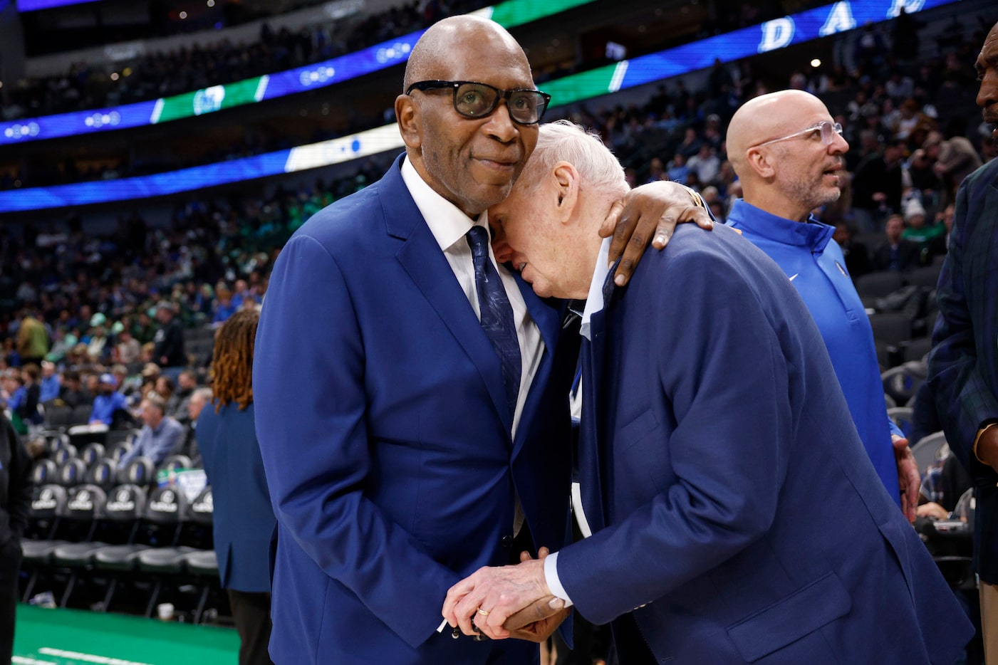 Dallas Mavericks legend Mark Aguirre, left, hugs Dallas Mavericks co-founder Norm Sonju...