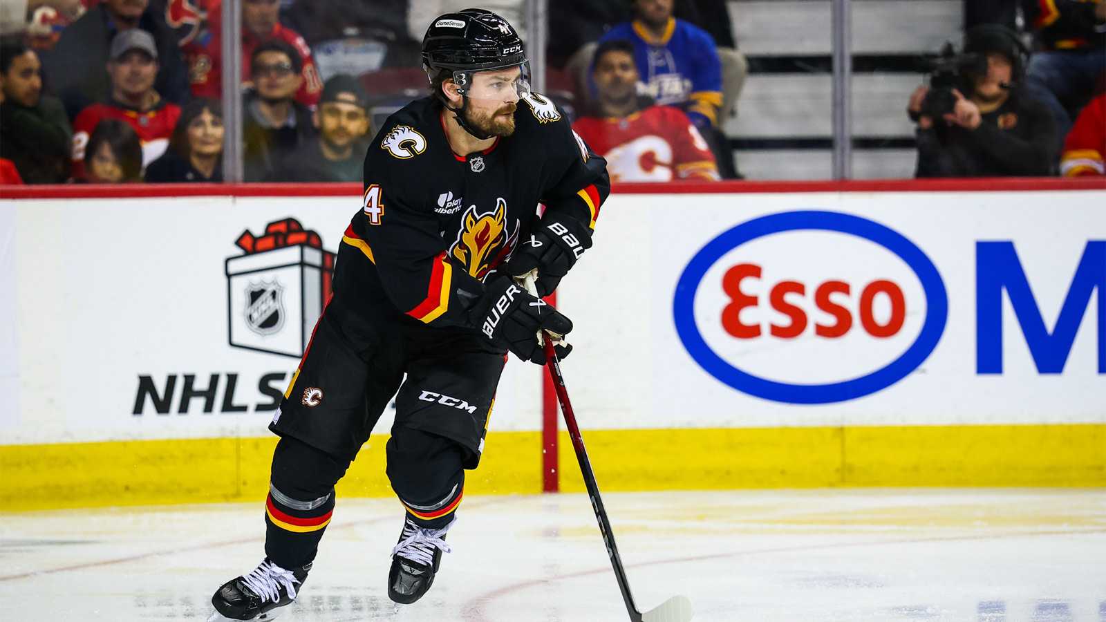 Calgary Flames defenseman Rasmus Andersson (4) skates with the puck against the Buffalo Sabres during the third period at Scotiabank Saddledome.