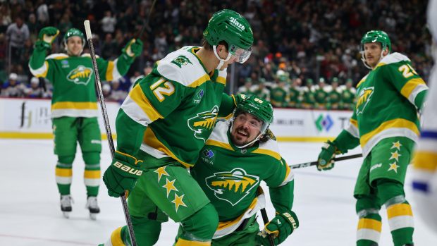 Team members celebrate on the ice.