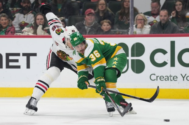 Chicago Blackhawks defenseman Louis Crevier (46) and Minnesota Wild right wing Mats Zuccarello (36) battle for the puck