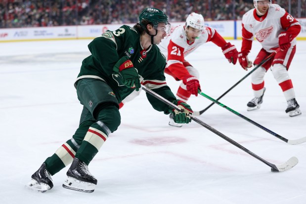 Minnesota Wild defenseman Quinn Hughes, left, skates with the puck as Detroit Red Wings left wing James van Riemsdyk (21) defends during the first period of an NHL hockey game Thursday, Jan. 22, 2026, in St. Paul, Minn. (AP Photo/Matt Krohn)