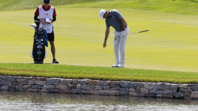 Jun 20, 2025; Cromwell, Connecticut, USA; Scottie Scheffler drops a ball after hitting into the water on the 17th hole during the second round of the Travelers Championship golf tournament.