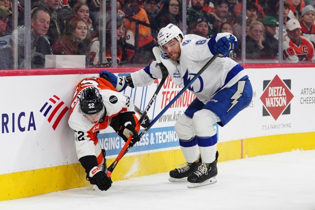 Tampa Bay Lightning's Erik Cernak, right, checks Philadelphia Flyers' Denver Barkey along the boards during the second period of an NHL hockey game, Saturday, Jan. 10, 2026, in Philadelphia. (AP Photo/Derik Hamilton)