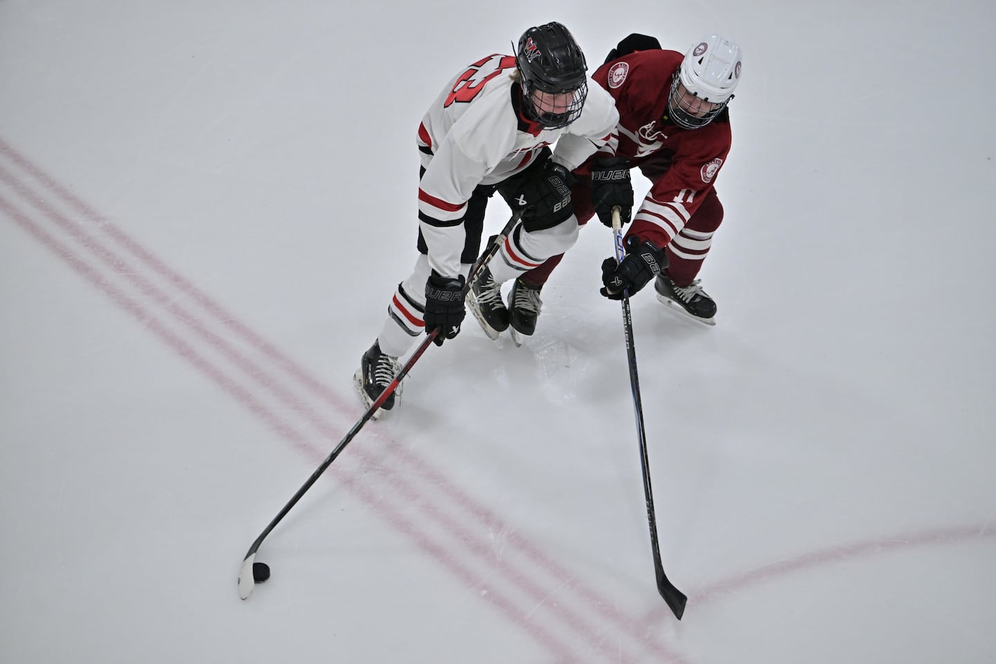 Winchester's Eli Krogmeier (left) attempts to skate past Nolan Russell of Arlington.