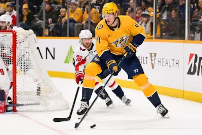 Nashville Predators forward Michael McCarron skates with puck behind the net