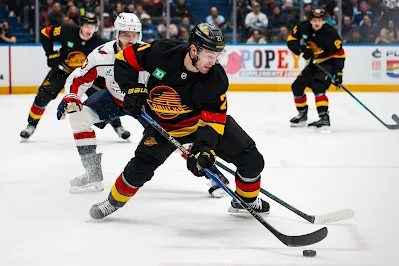 Vancouver Canucks forward Nils Hoglander skates with the puck during 2025 game.